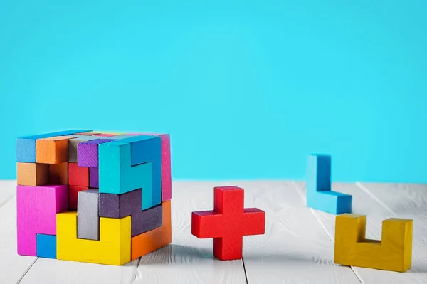 Concept of decision making process. Concept of creative, logical thinking. Different geometric shapes wooden blocks on white wooden background, copy space. Geometric shapes in different colors.
