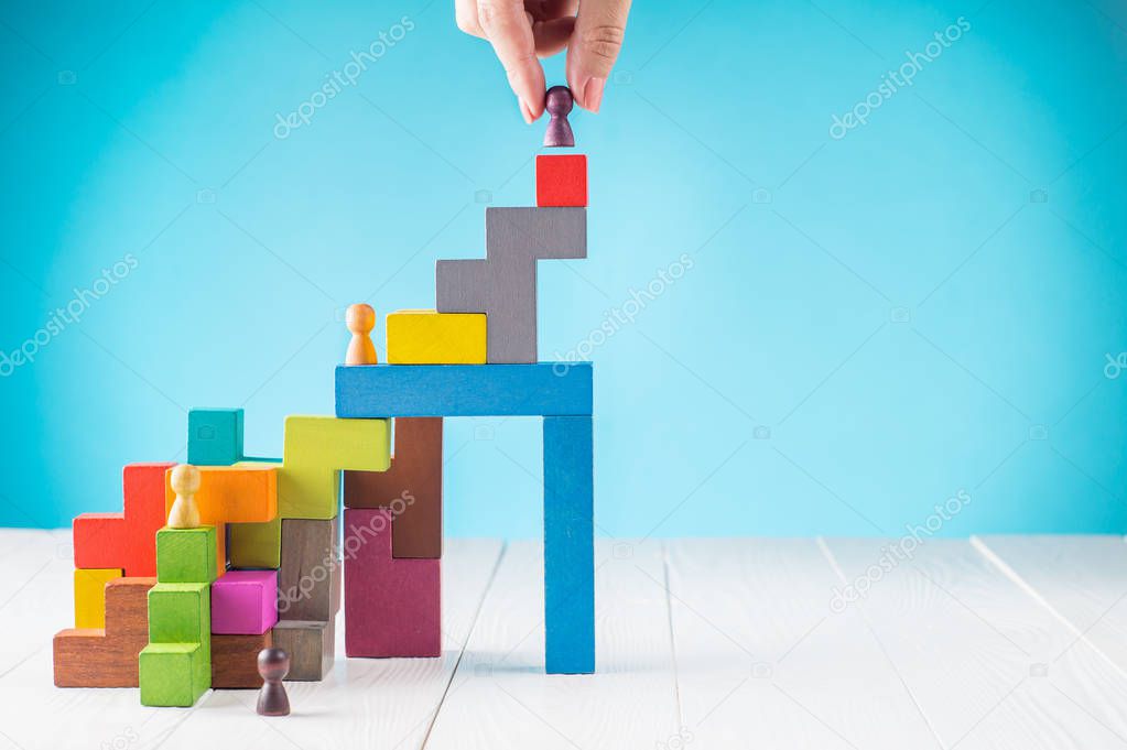 Success building concept. The leader's hand helps in career. Helping hands. Personal development, personal and career growth, progress and potential. People standing on wood block as step stair. 