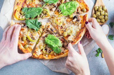 Bir dilim pizza erkek ve kadın el atın dilimlenmiş. Pizza kesim tablodan alarak eller. İtalyan pizza domates sosu, mantar, tavuk, parmesan, granit masada biber. Üstten görünüm, düz yatıyordu. 