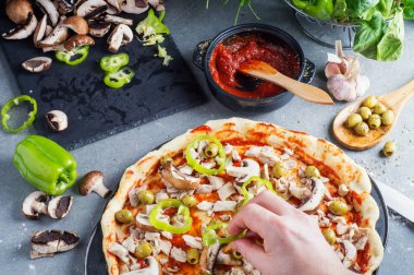 Pizza Hazırlık, çiğ hamur malzemeleri tarafından çevrili. Bir adamın elini zeytin pizza hamur yayılır. 