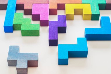 Arka plan. Farklı renkli şekiller ahşap bloklar üzerinde bej arka plan arka plan, yakın çekim. Farklı renklerde geometrik şekiller. Yaratıcı, mantıksal düşünme veya problem çözme kavramı. 