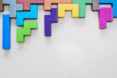 Farklı renkli ahşap bloklar bej renkli arka plan, düz yatıyordu üzerinde şekillendirir. Geometrik şekiller farklı renklerde, üstten görünüm. Yaratıcı, mantıksal düşünme veya problem çözme kavramı. Kopya alanı.