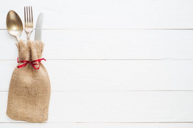 Rustik çatal bıçak seti: vintage bıçak, çatal ve kaşık Beyaz ahşap zemin üzerinde. Tablo kopya alanı, üstten görünüm, düz ile çuval bezi üzerinde Antik çatal bıçak takımı ile yatıyordu. Çuval bezi içinde sarılı çatal bıçak takımı.