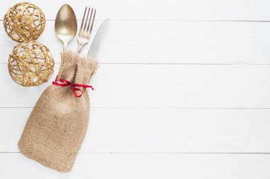 Rustik çatal bıçak seti: vintage bıçak, çatal ve kaşık Beyaz ahşap zemin üzerinde. Tablo kopya alanı, üstten görünüm, düz ile çuval bezi üzerinde Antik çatal bıçak takımı ile yatıyordu. Çuval bezi içinde sarılı çatal bıçak takımı.