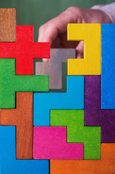 手与木制玩具块 商人建造了一座木制的多色方块塔 企业成功 成就的理念 — 图库照片