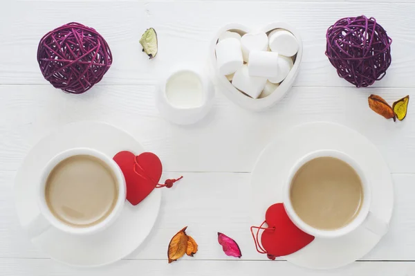 Desayuno romántico con un par de tazas de café blanco sobre blanco Imagen de archivo