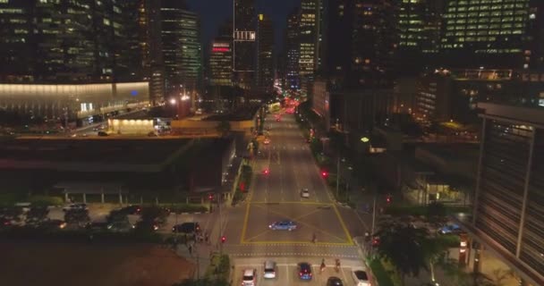 Night traffic on the road between skyscrapers in the city — Stock Video