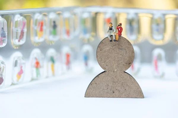 Miniature people, recruiters on wooden people sign for finding t