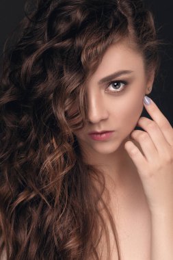 Şık bir saç modeli, profesyonel makyaj, temiz cilt Studio karanlık bir arka plan üzerinde poz ile esmer kız