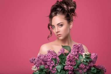 Sevimli Genç kız modeli kıvırcık saçlı ihale ve profesyonel makyaj elinde metin için yer ile izole bir pembe mor çiçekler güzel bir buket tutar.