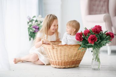 Büyük bir parlak odada küçük kız kardeşi ile ablası çalış. Onlar sevinçle oynamak ve gülmek