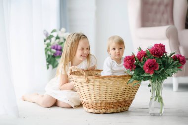 Büyük bir parlak odada küçük kız kardeşi ile ablası çalış. Onlar sevinçle oynamak ve gülmek