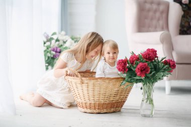 Büyük bir parlak odada küçük kız kardeşi ile ablası çalış. Onlar sevinçle oynamak ve gülmek