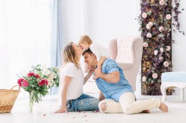 Geniş parlak bir oda içinde onların genç çocuk ile anne oynamak. Annem ve babam sarılmak ve birbirlerine öpücük