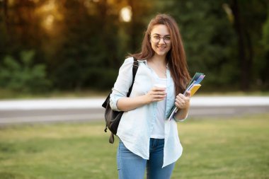 Notebook ve kulakları için çevrimiçi bir konferans dinlerken kulaklık ile bir klasör olan bir genç kız öğrenci. O onun anadil metin çevirir ve sınavları için hazırlar