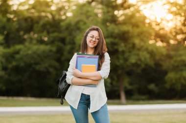 Notebook ve kulakları için çevrimiçi bir konferans dinlerken kulaklık ile bir klasör olan bir genç kız öğrenci. O onun anadil metin çevirir ve sınavları için hazırlar