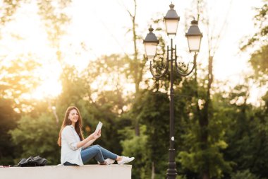 Notebook ve kulakları için çevrimiçi bir konferans dinlerken kulaklık ile bir klasör olan bir genç kız öğrenci. O onun anadil metin çevirir ve sınavları için hazırlar