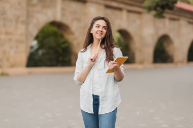 Bir defter ve bir kalem onun elinde genç bir kızla ödevini çözme. notlar not defteri için yazıyor