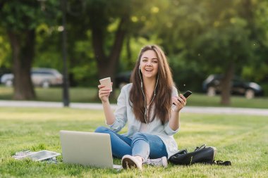 Notebook ve kulakları için çevrimiçi bir konferans dinlerken kulaklık ile bir klasör olan bir genç kız öğrenci. O onun anadil metin çevirir ve sınavları için hazırlar