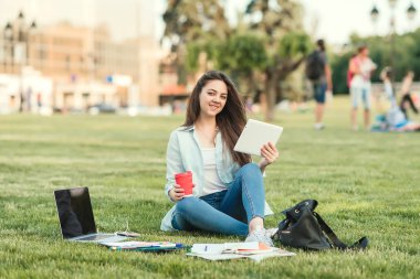 Notebook ve kulakları için çevrimiçi bir konferans dinlerken kulaklık ile bir klasör olan bir genç kız öğrenci. O onun anadil metin çevirir ve sınavları için hazırlar