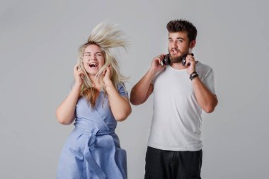 Kablosuz kulaklık yüksek sesle müzik dinlemek genç çift. Uzun saç sallayarak ve dans, elele kulakları yakınındaki bir kız