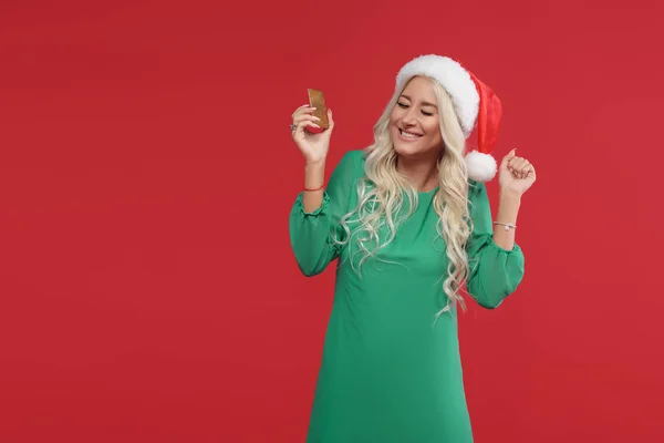 Uma Jovem Loira Usando Chapéu Papai Noel Vestido Verde Está — Fotografia de Stock