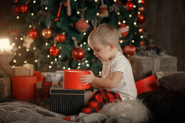 Glücklicher Kleiner Lächelnder Junge Roten Pyjama Mit Weihnachtsgeschenkbox Wohnzimmer Hause — Stockfoto