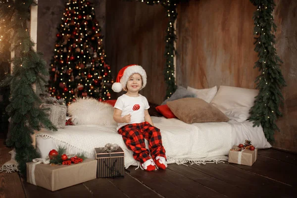 클로스 모자에서 귀여운 크리스마스 앉아서 막대기에 달콤한 사탕을 — 스톡 사진