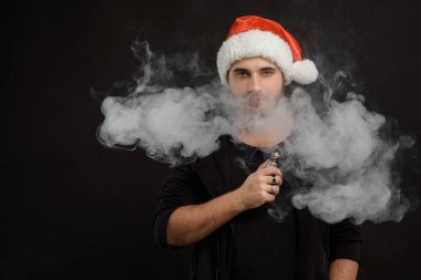 Noel Baba kırmızı şapka yasaktır elektronik sigarette sakallı adam. Vape kalem. vape duman. Noel kavramı