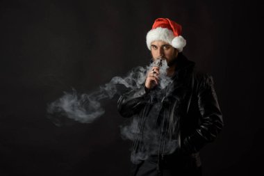 Noel Baba kırmızı şapka yasaktır elektronik sigarette sakallı adam. Vape kalem. vape duman. Noel kavramı