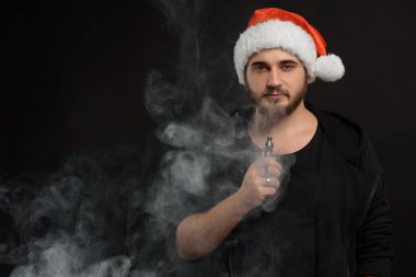 Noel Baba kırmızı şapka yasaktır elektronik sigarette sakallı adam. Vape kalem. vape duman. Noel kavramı