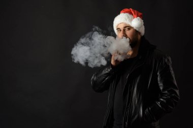 Noel Baba kırmızı şapka yasaktır elektronik sigarette sakallı adam. Vape kalem. vape duman. Noel kavramı