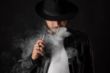Adam vaping mod Buhar siyah stüdyo arka plan adlı parçasıyla birlikte kullanılmalıdır. Sakallı adam e-sigara tütün çıkmak için. Buharı ve alternatif nikotin ücretsiz sigara kavramı, portre