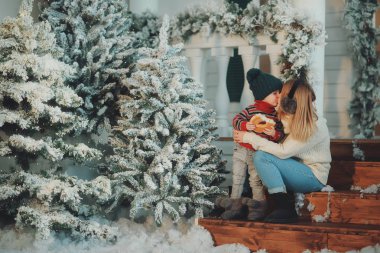 Mutlu anne ve tapılası bebeğin portresi Noel 'i kutluyor. Yeni yıl tatili. Annenle birlikte Noel ağacı ve süslemelerle süslenmiş bir odada..