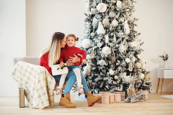 幸福的家庭 母亲和女孩坐在圣诞树下的椅子上 在舒适的客厅里许个愿 — 图库照片