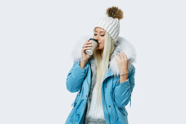 青いコートにホワイト バック グラウンドでコーヒー カップを保持している毛皮の女性 コンセプト コーヒー — ストック写真