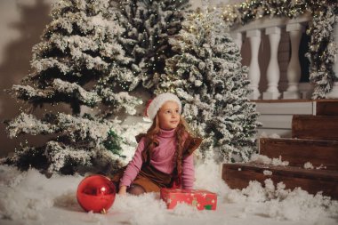 Noel ağacı arka plan üzerinde mevcut bir hediye kutusu ile kız mutlu çocuk