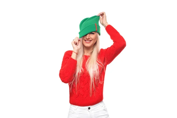 ファッション ニット緑帽子と赤いセーターの分離の白い背景の上楽しんで幸せな若いブロンドの女 — ストック写真
