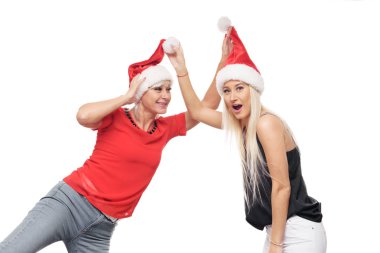 Bir mutlu ve eğlenceli anne ve kızı Santa şapka giymiş beyaz arka plan üzerinde izole poz portre siyah ve kırmızı elbise. Aile ilişkileri, hugs sıcak ve eğlenceli hale getirmek