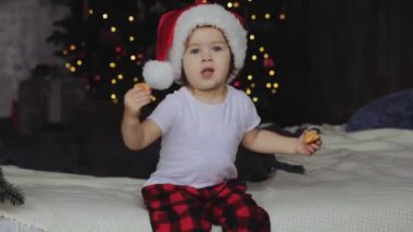 Çocuk bir çubuğa tatlı şeker yemek, eğlenmek Noel zamanı Noel Baba kostüm. Merry Xmas kavramı