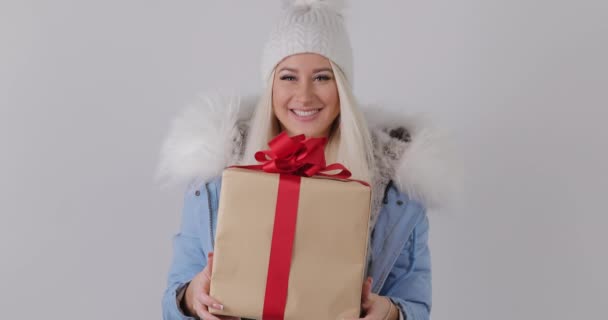 幸せの冬の毛皮のコート 彼女の手を保持している存在に驚く女性は願うし ギフト ボックスを取得します 白背景 — ストック動画