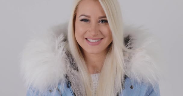 金髪女性の毛皮でコート スタジオ ホワイト バック グラウンド スローモーション で雪が吹き — ストック動画