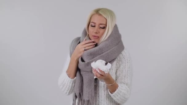 Zieke Blonde Vrouw Een Gebreide Warme Sjaal Niest Witte Achtergrond — Stockvideo