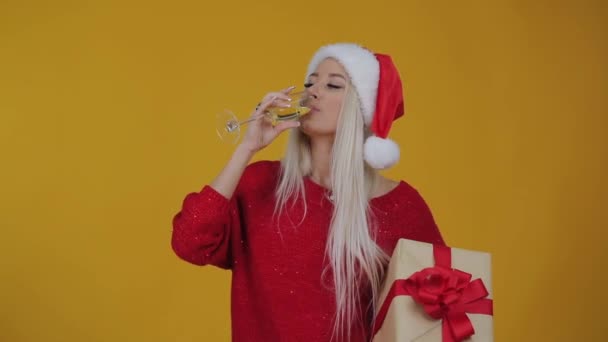 Glückliche Blonde Frau Mit Weihnachtsmann Hut Mit Geschenkbox Über Gelbem — Stockvideo