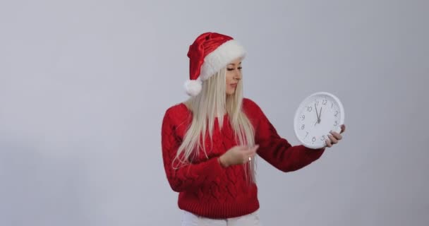 ホワイト スタジオの背景にサンタ クロースの帽子の時計の遅い正月と大きな壁とクリスマス ショッピングの女の子 — ストック動画