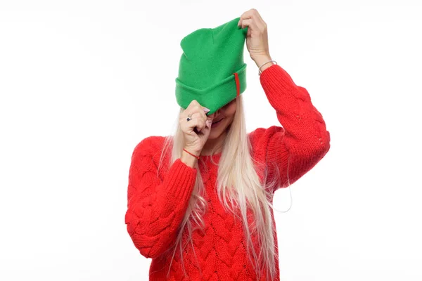 明るいを着てファッション金髪女性ニット緑の帽子と赤いセーターの分離の白い背景の上楽しんで — ストック写真