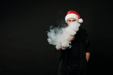Noel Baba kırmızı şapka yasaktır elektronik sigarette sakallı adam. Vape kalem. vape duman. Noel kavramı