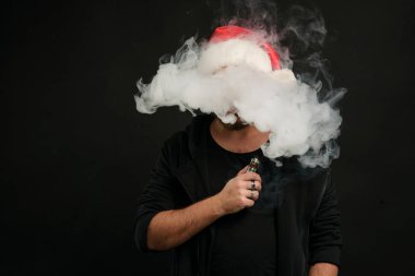 Noel Baba kırmızı şapka yasaktır elektronik sigarette sakallı adam. Vape kalem. vape duman. Noel kavramı