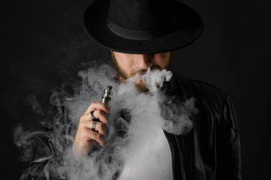 Adam vaping mod Buhar siyah stüdyo arka plan adlı parçasıyla birlikte kullanılmalıdır. Sakallı adam e-sigara tütün çıkmak için. Buharı ve alternatif nikotin ücretsiz Sigara kavramı