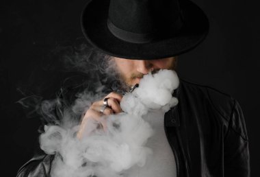 Adam vaping mod Buhar siyah stüdyo arka plan adlı parçasıyla birlikte kullanılmalıdır. Sakallı adam e-sigara tütün çıkmak için. Buharı ve alternatif nikotin ücretsiz Sigara kavramı